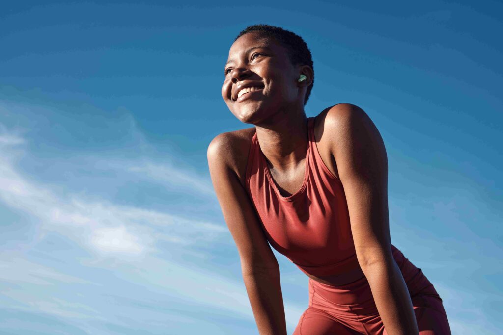 Smiling Black female athlete after a run, relaxed and anxiety-free—showing how exercise helps with anxiety.