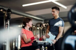 A personal trainer working out with a client. Personal trainers can help you find an support your motivation for fitness.
