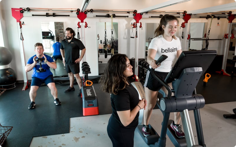 Studio Personal Training | Flexible Packages | Pledge to Fitness® Assessments two people training with personal trainers | female trainer stretching -personal training and massage therapy - Pledge to Fitness