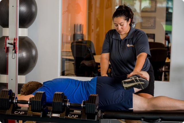 A Pledge To Fitness massage therapist administering a recovery massage to a client in their fitness studio in Houston, TX.