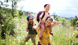 Family hiking outdoors, enjoying nature and building sustainable fitness through active, quality time together.