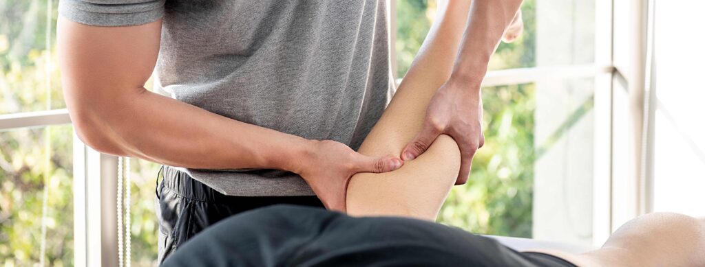 Massage therapist performing a deep tissue massage on a client's calf.