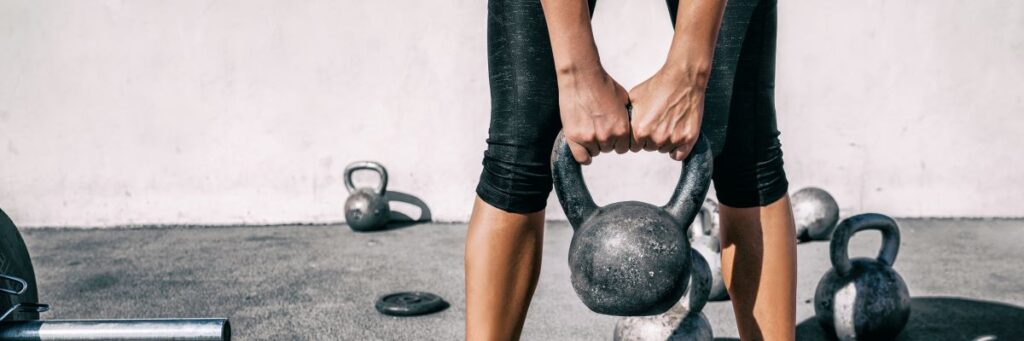 A woman performing a strength training exercise with weightlifting with a Kettlebell.