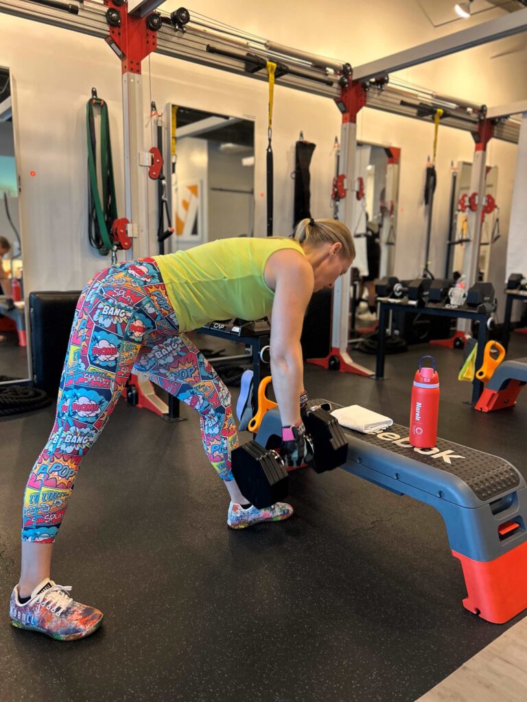 A young mother and career executive building muscle and strength at a fitness studio.