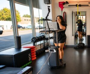 Personal trainer leading a live online fitness session from the Pledge To Fitness studio.