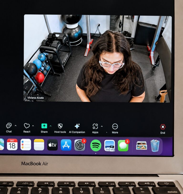 Laptop displaying a Pledge To Fitness coach leading a virtual personal training session from a private fitness studio.