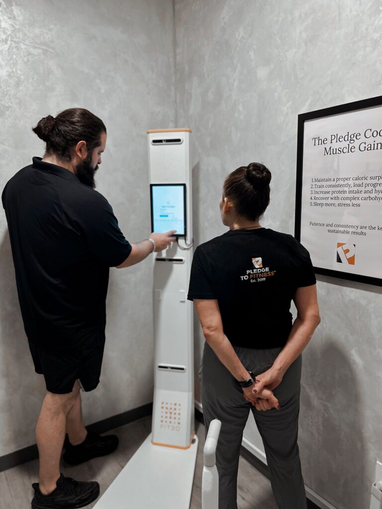Personal trainer guiding a client through a Fit3D body scan at Pledge To Fitness®.